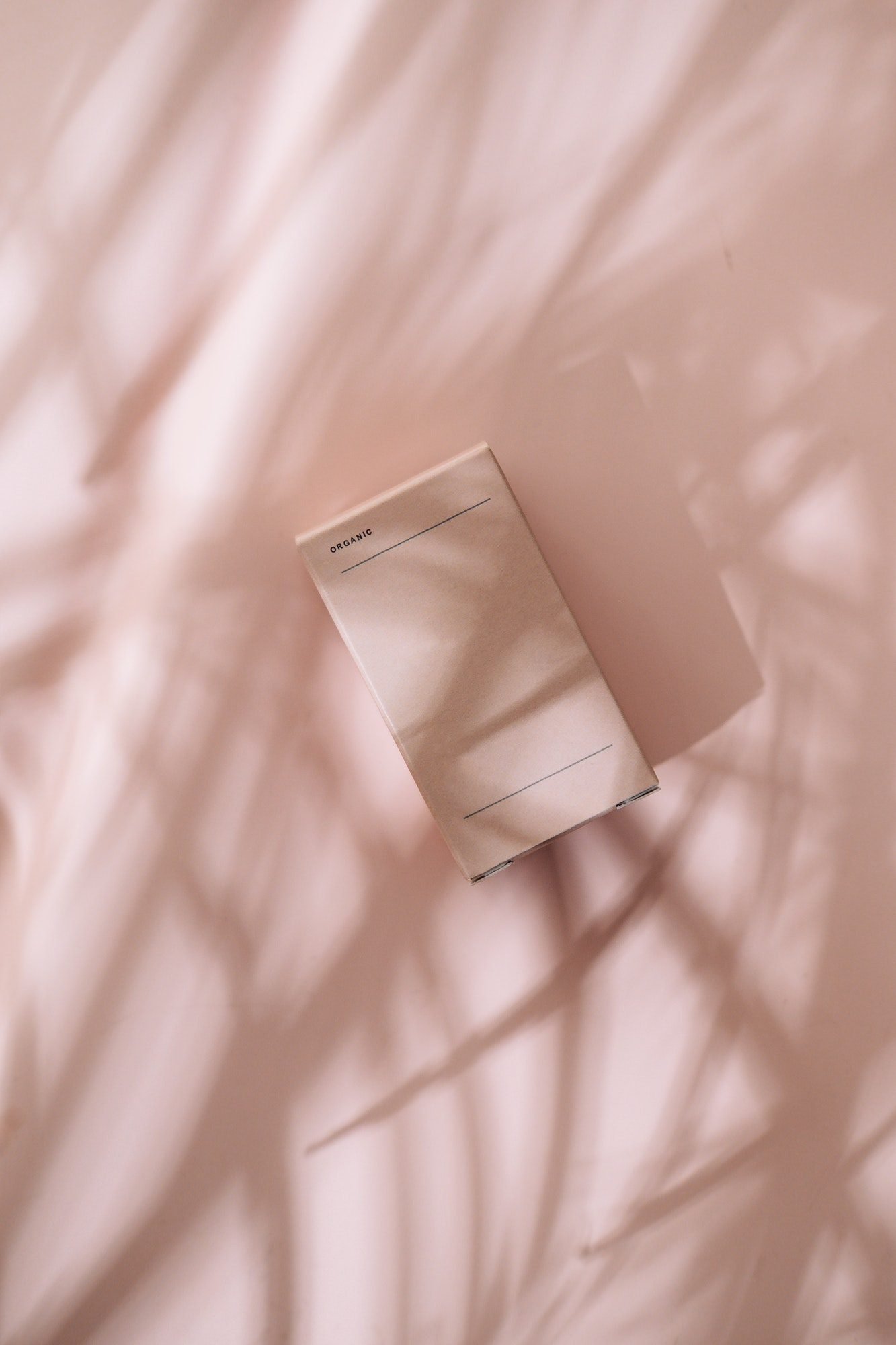 minimalist beauty box on pastel pink in leaves shadows - DIB Technologies